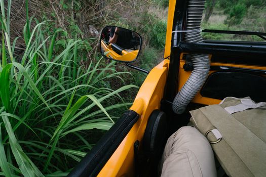 Crop man taking selfie in offroader rear viewer