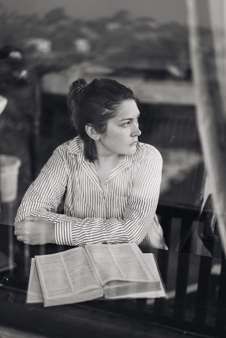 Serious Young Lady With Thick Book Looking Away