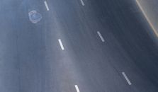 From above abstract background of empty asphalt road with manhole and symmetric white lines