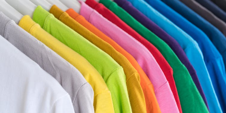 Stack Of Multicolored T Shirts On Hangers