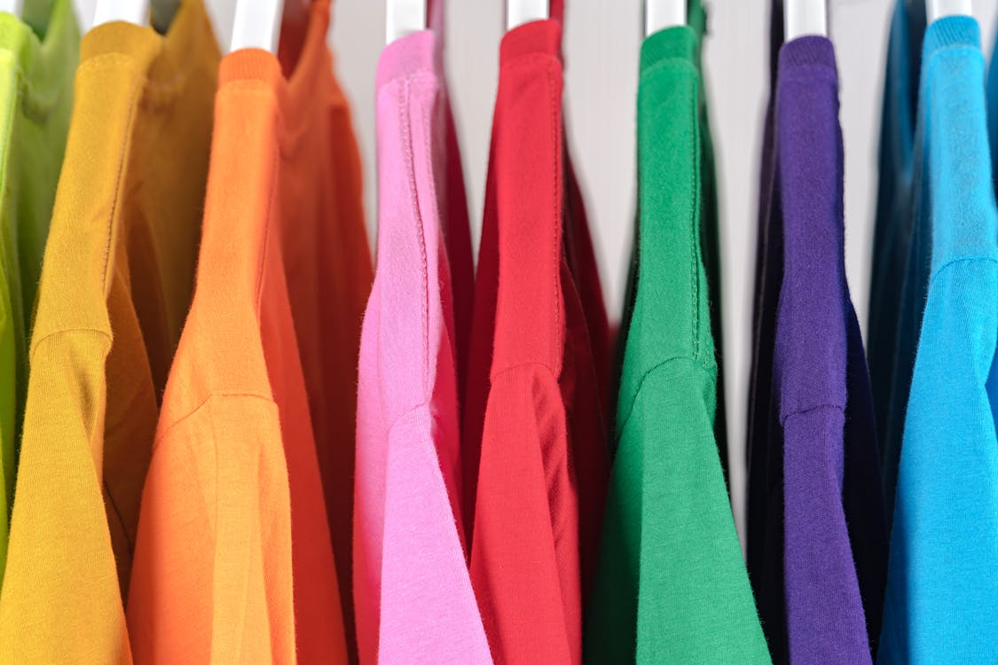 Free Collection of colorful cotton t shirts on hangers in store Stock Photo