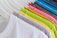 Closeup bright multicolored soft cotton t shirts hanging on rail in well organized wardrobe