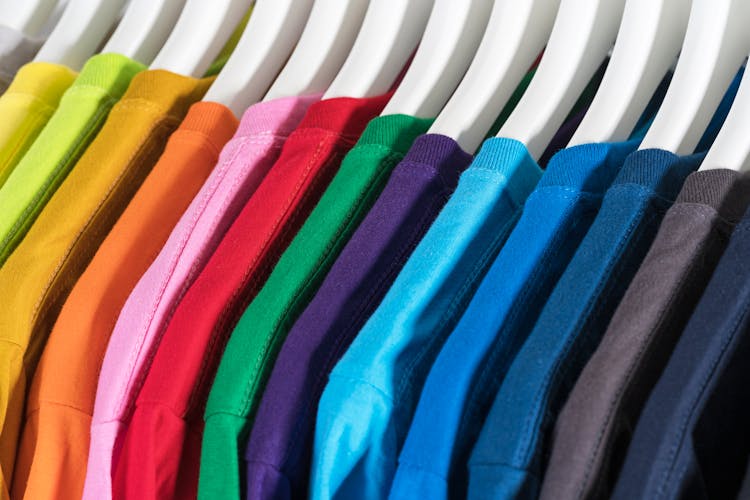 Set Of Colorful T Shirts Hanging On Racks