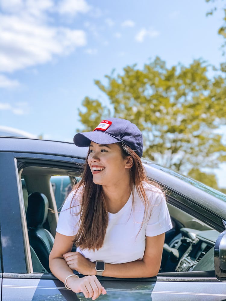 Happy Young Woman In Car In City