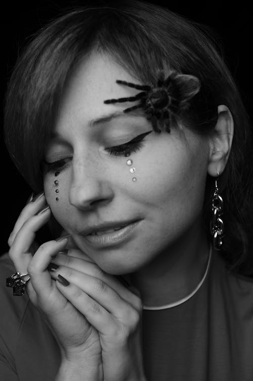 Young gentle woman with spider on face
