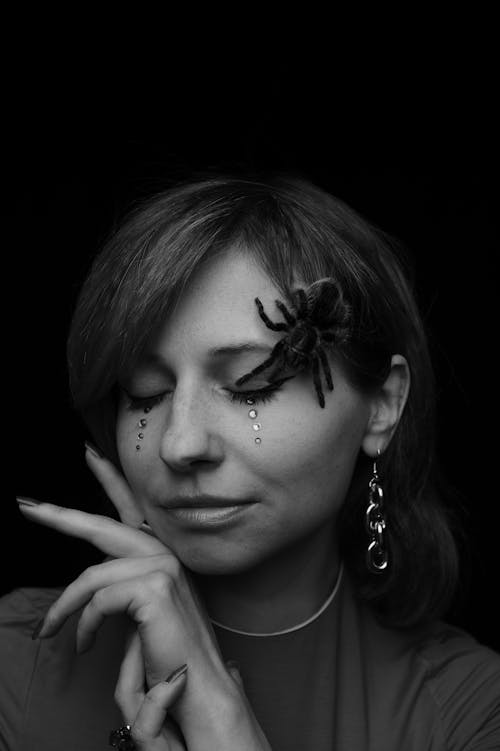 Young woman with decorative makeup and spider on face