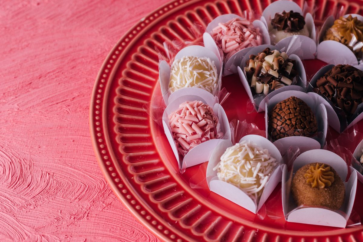 From above of delicious sweets with chocolate topping placed on pink ceramic plate