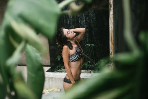 Free Sensual lady enjoying warm shower spray in resort pool Stock Photo
