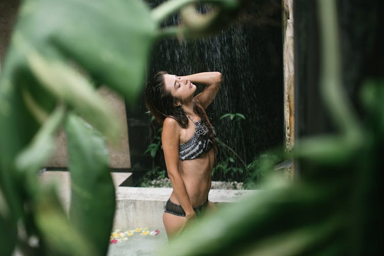 Sensual Lady Enjoying Warm Shower Spray In Resort Pool