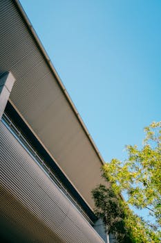 From below of facade of residential house in modern style under blue sky