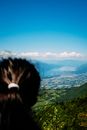 Woman admiring landscape with mountains and town on river shore