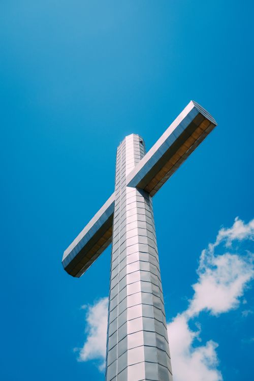Free From below of metal cross located on top of mountain in France at daytime Stock Photo