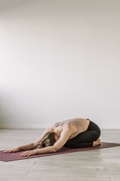 Woman Kneeling on a Yoga Mat