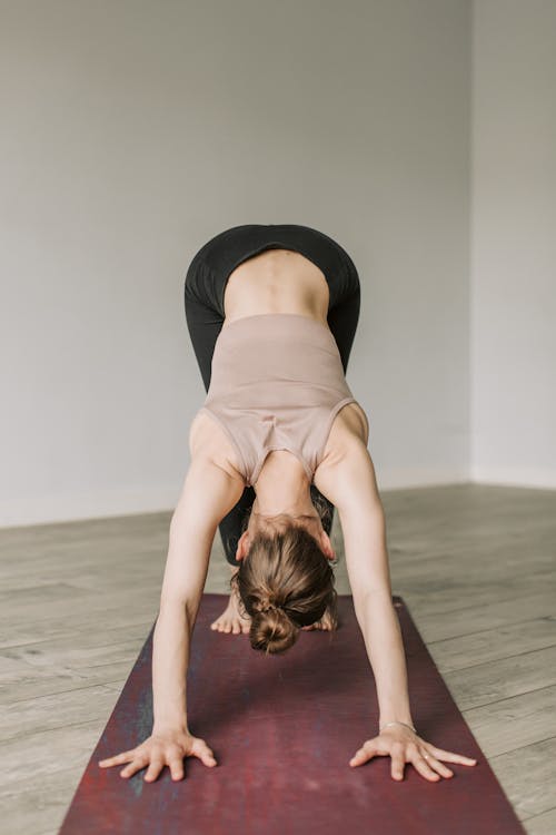 A Woman Balancing Her Body on a Yoga Mat