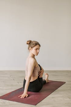 Woman in yoga pose on mat indoors, promoting fitness and mindfulness