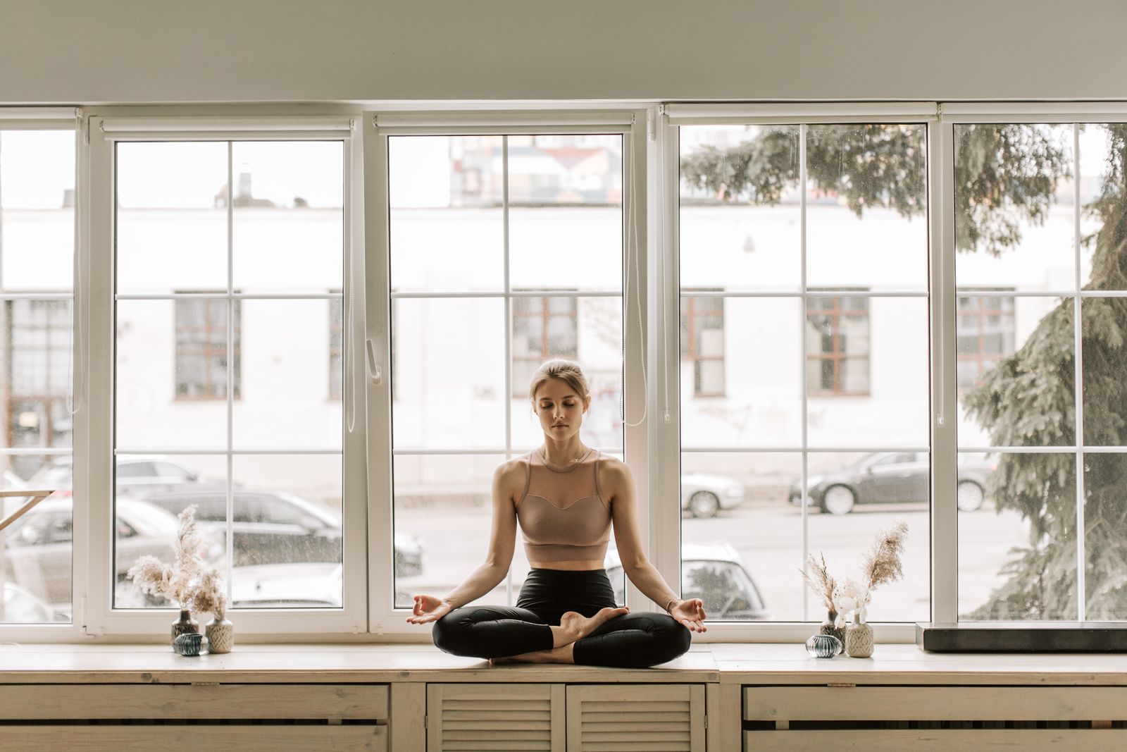 Person sitting calmly by a sunlit windowsill in the morning
