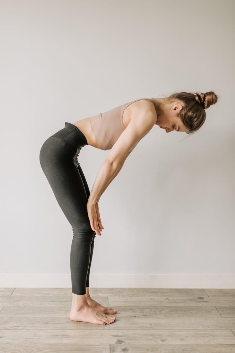 A Woman Wearing Activewear Standing While Touching Her Knee