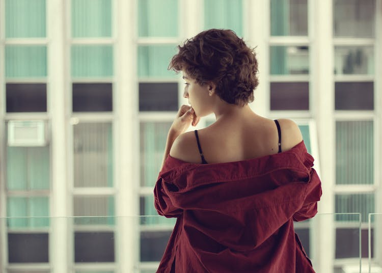 Back View Of A Woman Removing Red Shirt