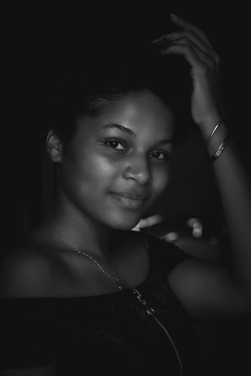 Free Graceful black and white portrait of a smiling woman in a relaxed pose, showcasing natural beauty. Stock Photo