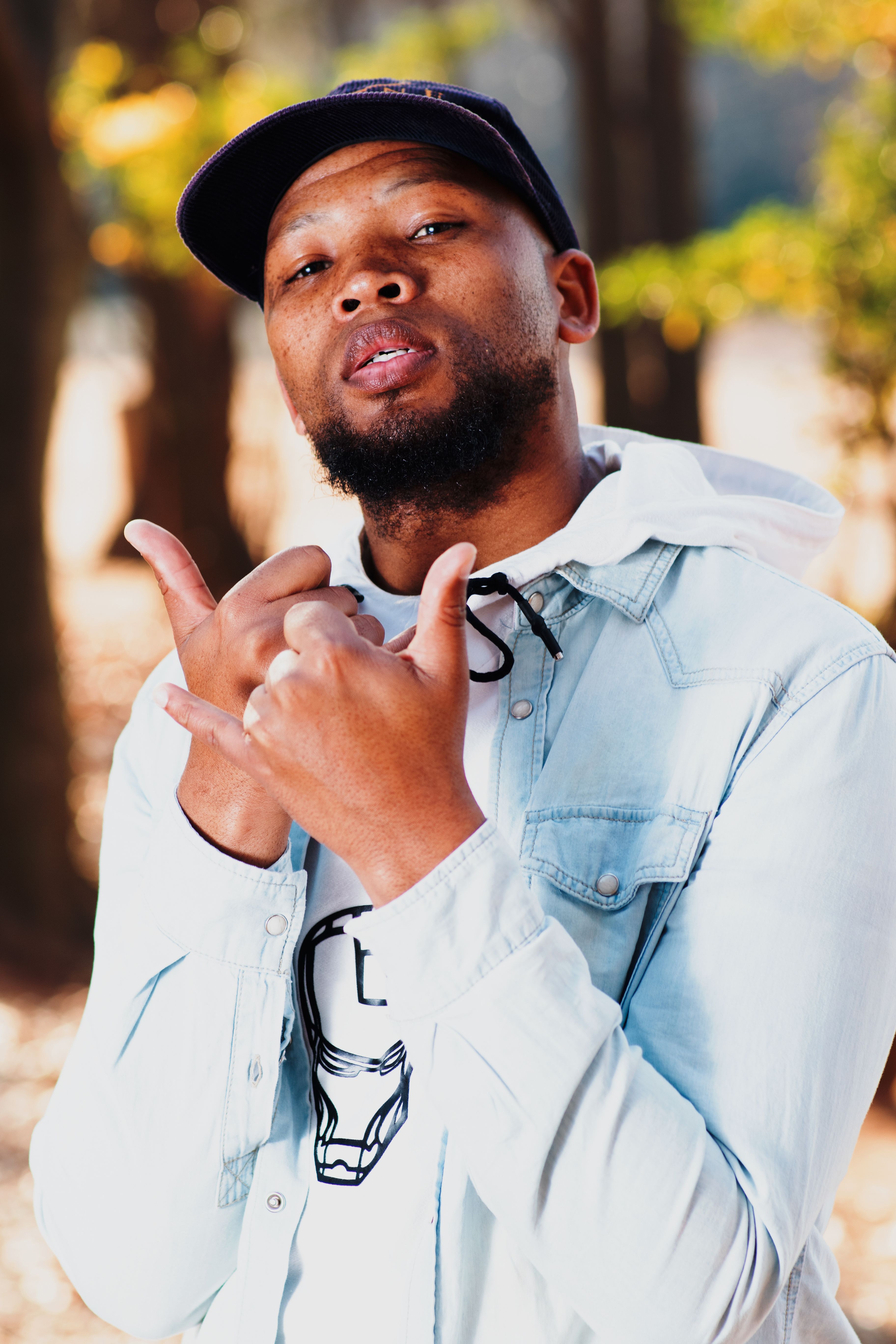 Portrait of a stylish young man in a denim jacket outdoors in Johannesburg.