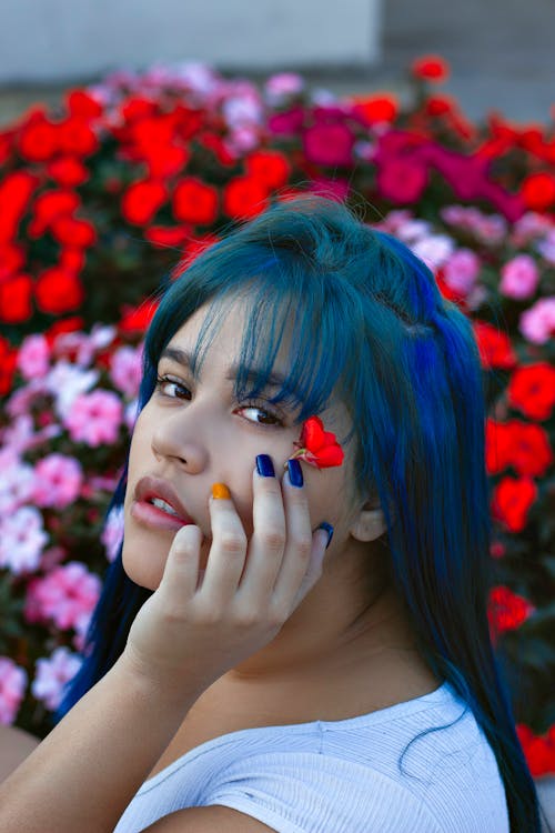 A Woman With Blue Hair Holding Red Flower