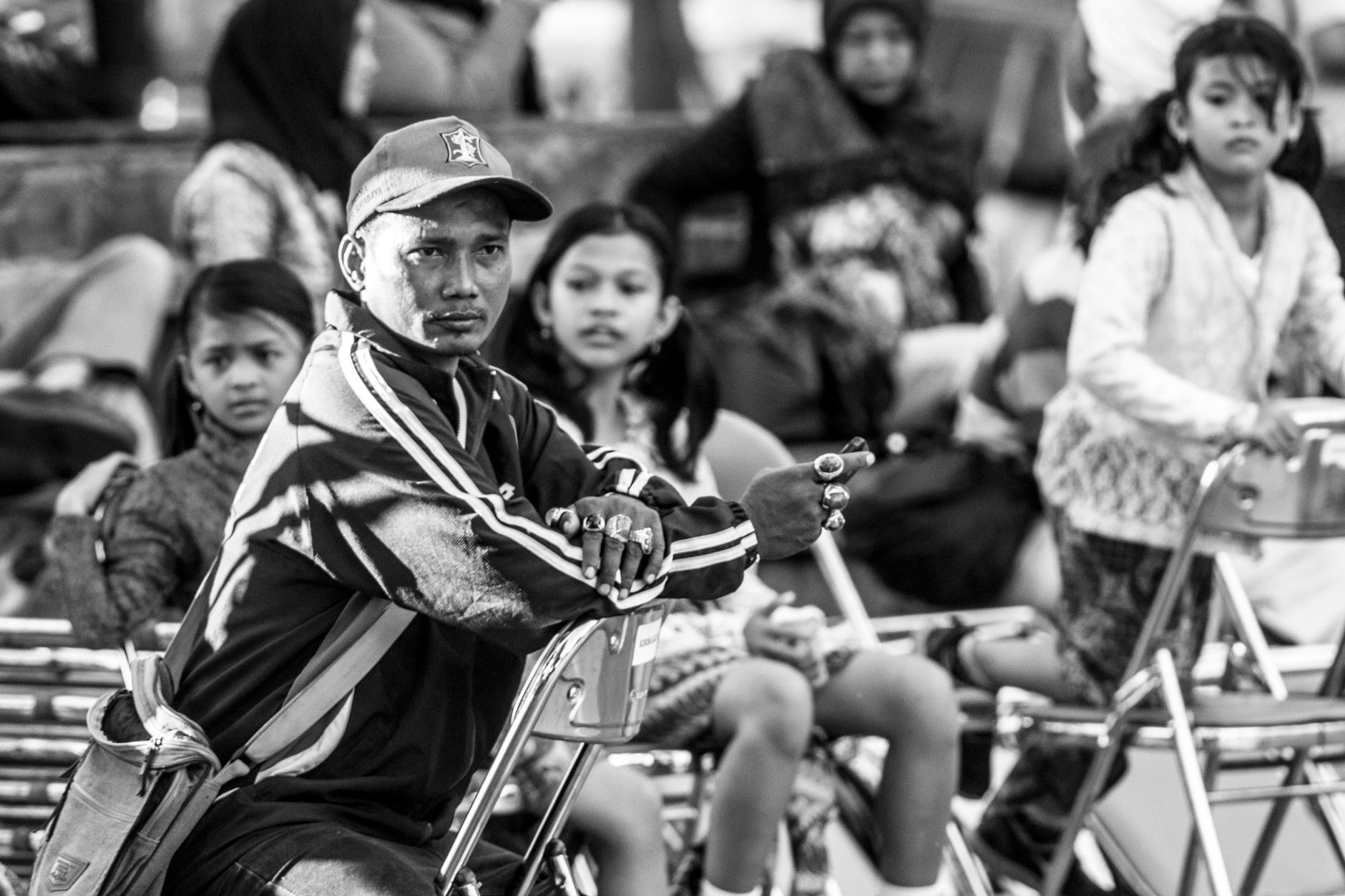 A monochrome photo capturing people seated outdoors in Surabaya, Indonesia.