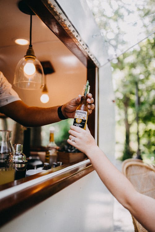 Free Person Holding a Beer Bottle Stock Photo