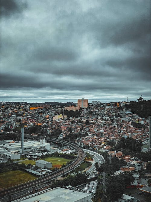 Drone view of town with roads and contemporary dwelling houses under gloomy sky