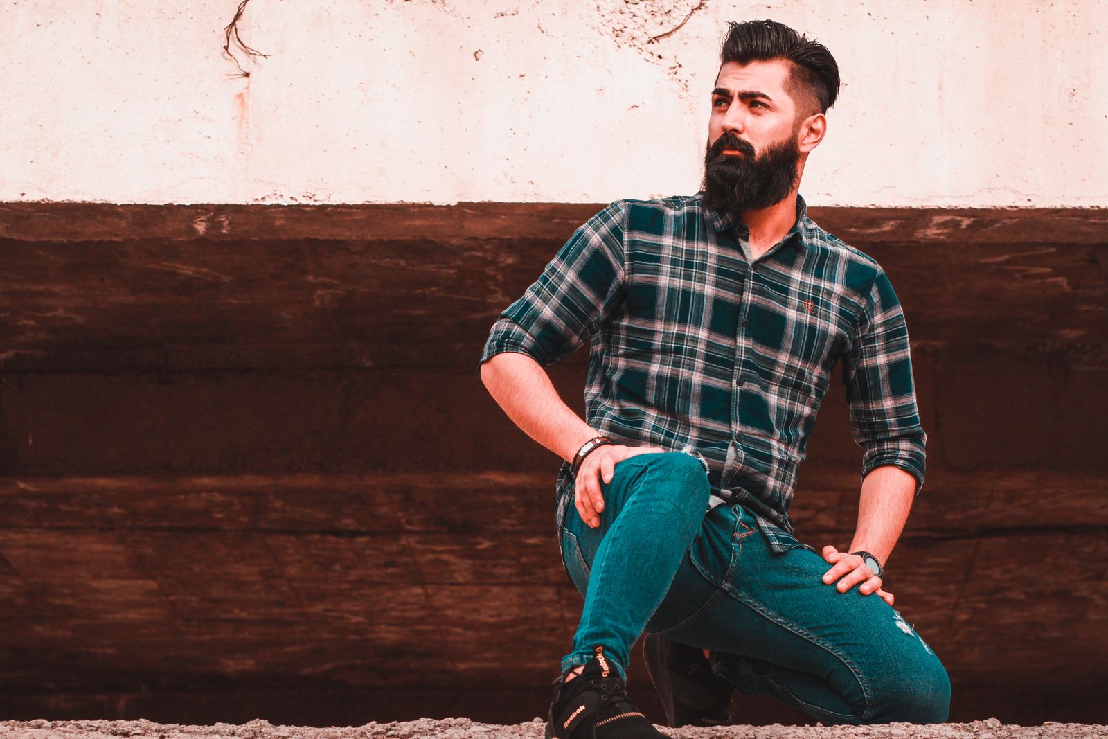 Homem usando camisa xadrez e jeans em um cenário externo