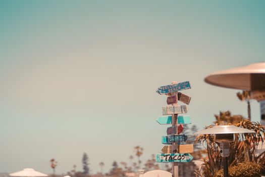 Colorful signpost with beach directions under a clear summer sky in Coronado, CA