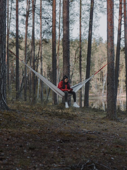 Woman Sitting in a Hammock in a Forest