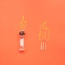 Cigarette lighter and matches placed on orange background