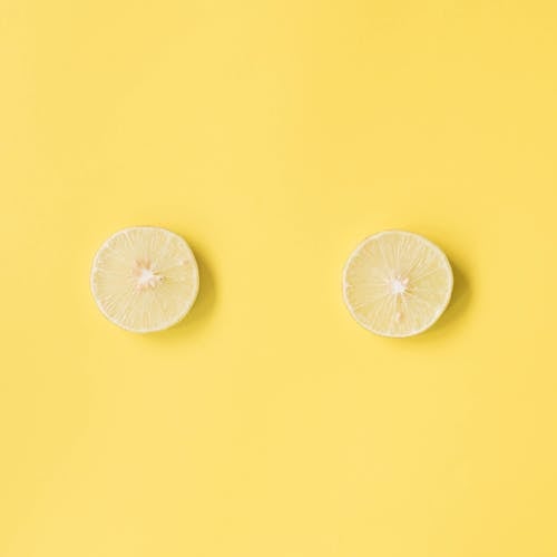 Free Top view flat lay composition of ripe slices of lemon arranged on yellow surface Stock Photo
