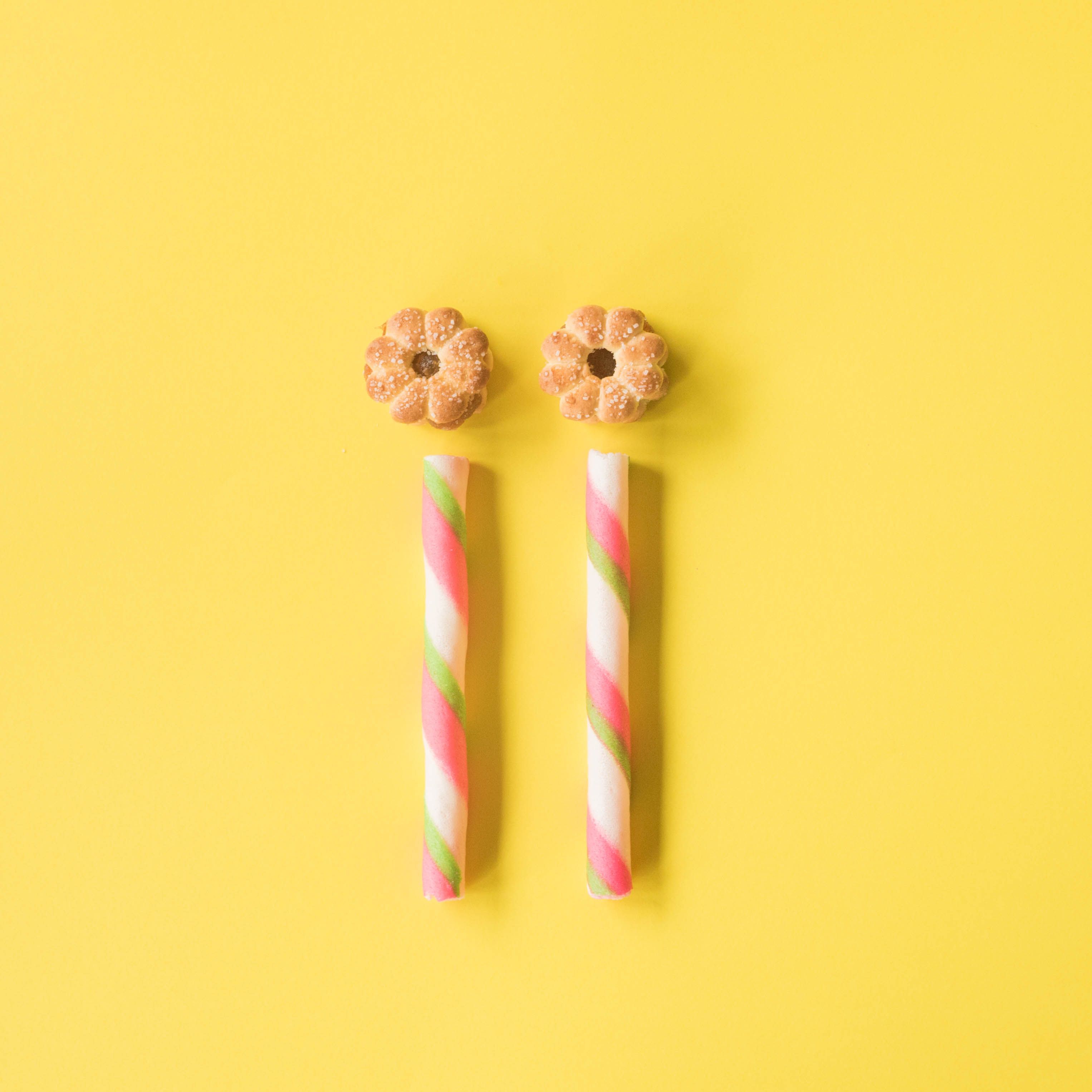Rolled waffles placed on yellow surface with cookies