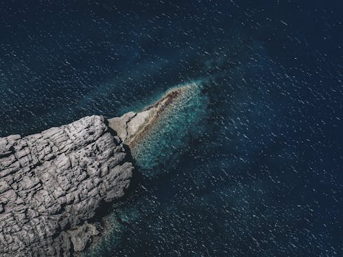 Rocky formation in wavy blue sea