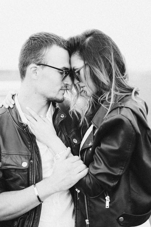 Couple Wearing Leather Jackets Holding Each Other and Touching Head to Head