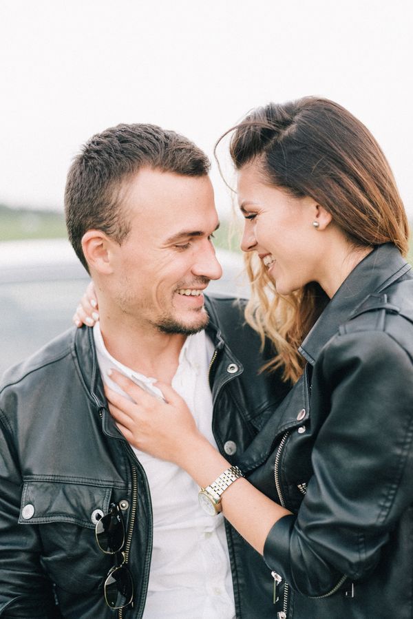 Couple wearing black leather jackets, smiling outdoors