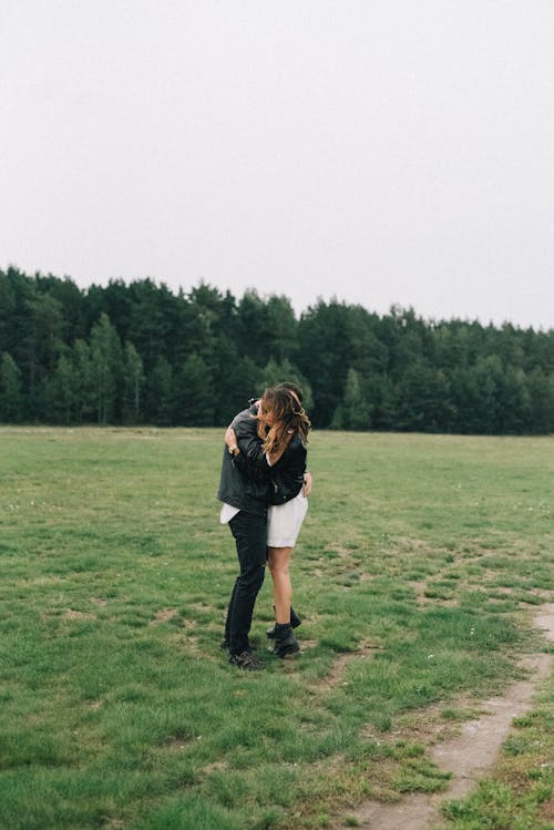 A Couple Hugging in a Grass Field 