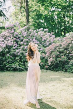 阳光明媚的花园里，一名女子优雅地站在盛开的花朵中，显得格外宁静