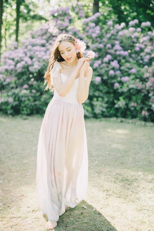 Femme En Robe Blanche Debout Sur Le Champ D'herbe Verte