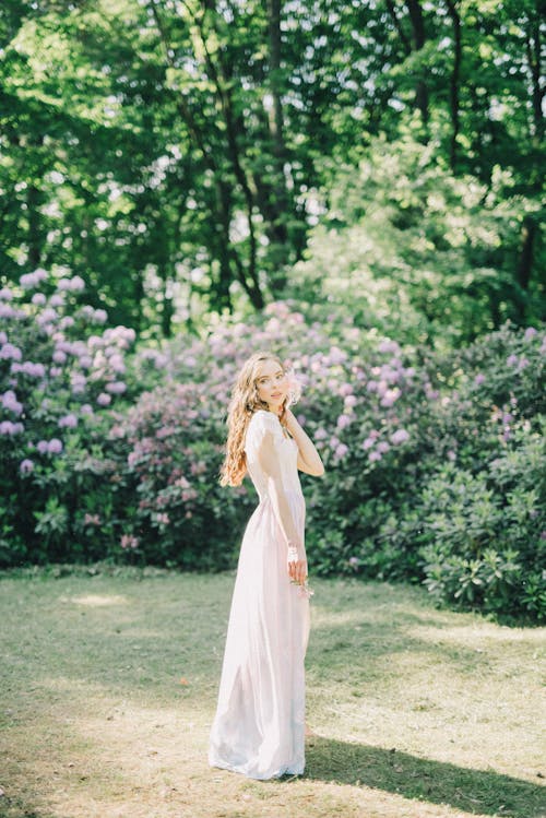 Femme En Robe Blanche Debout Sur Le Champ D'herbe Verte