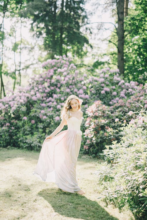 Femme En Robe Blanche Debout Sur Le Champ D'herbe Verte