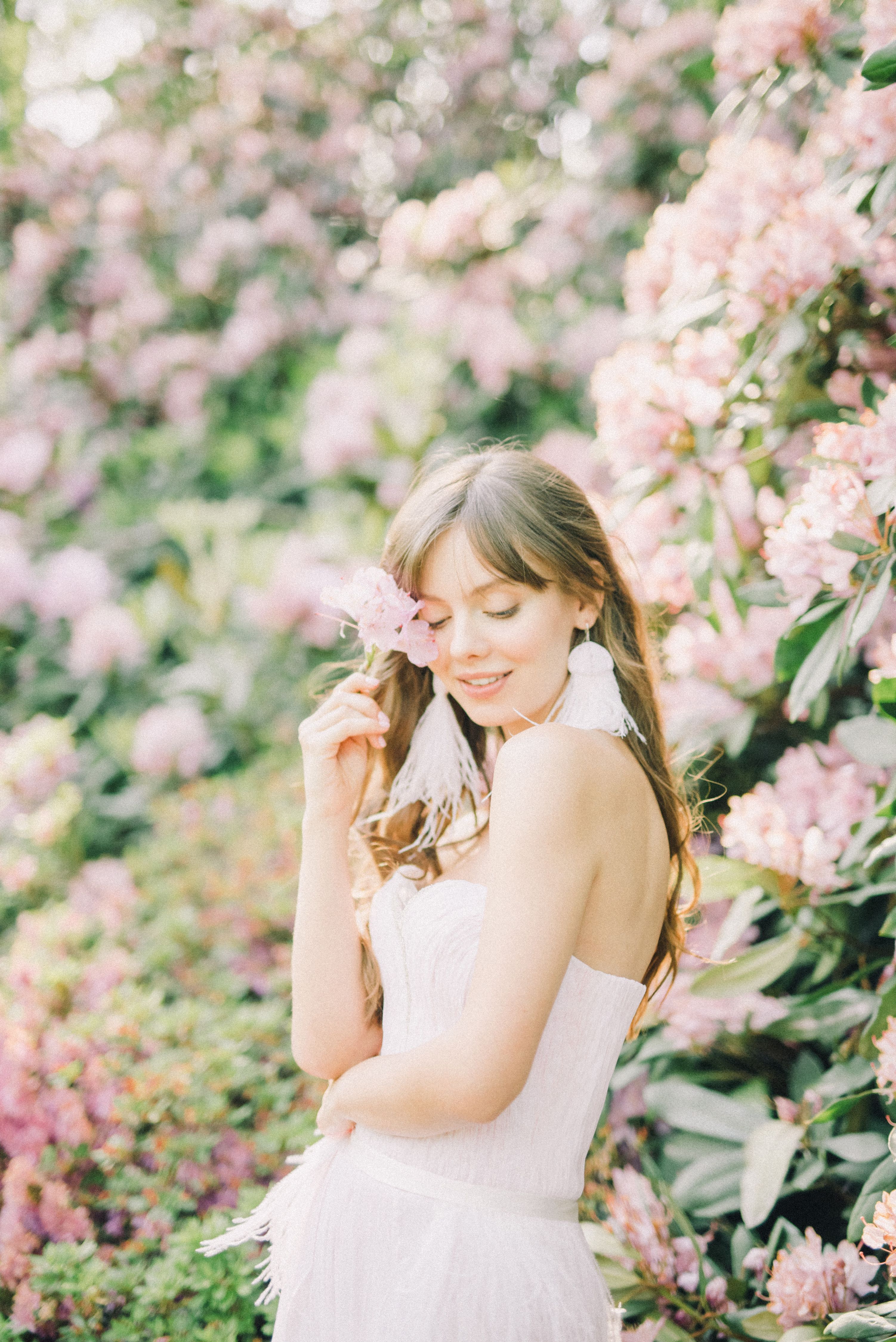 A Woman in White Dress Holding Pink Flower · Free Stock Photo