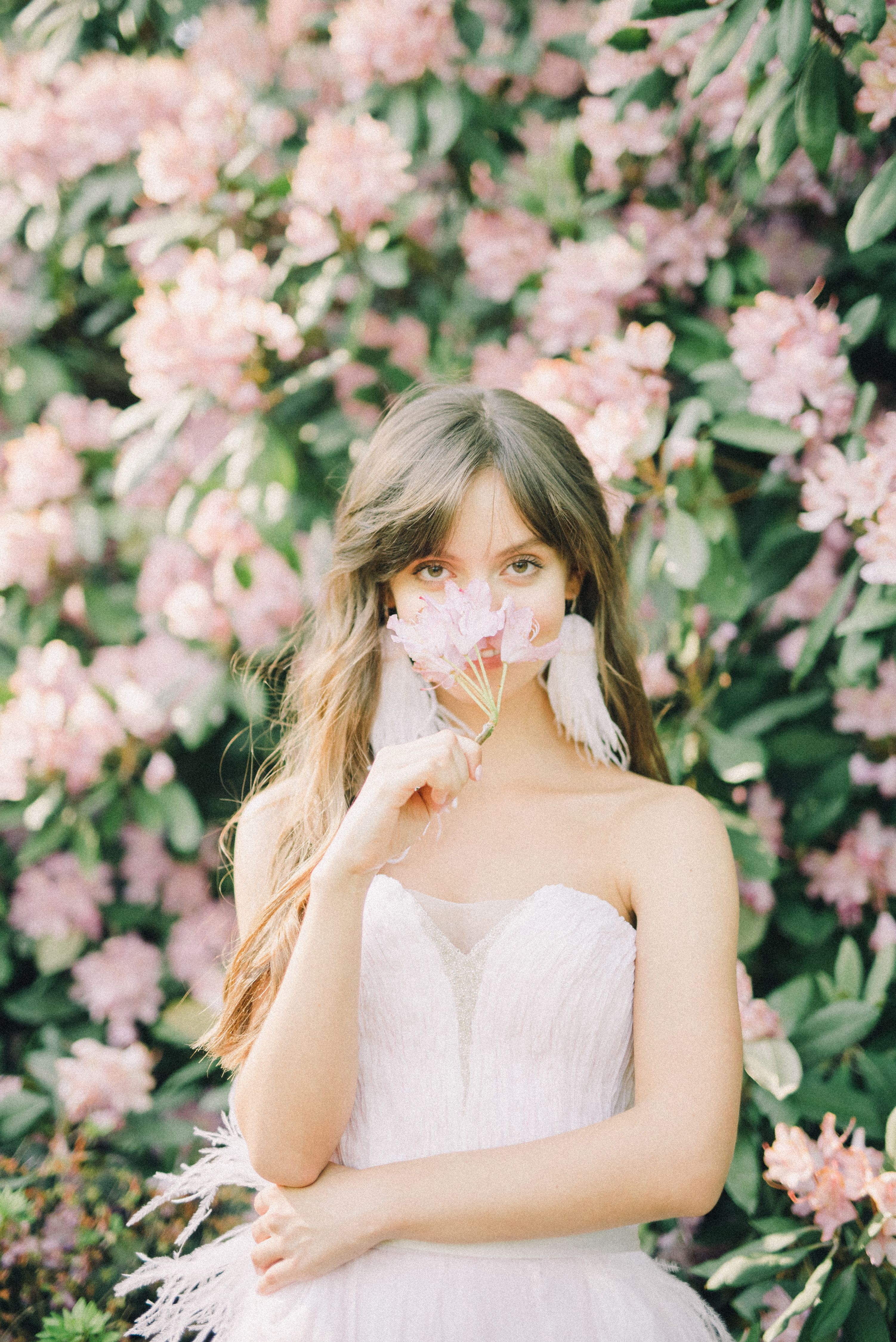 A Woman in White Tube Dress Holding Pink Flower · Free Stock Photo