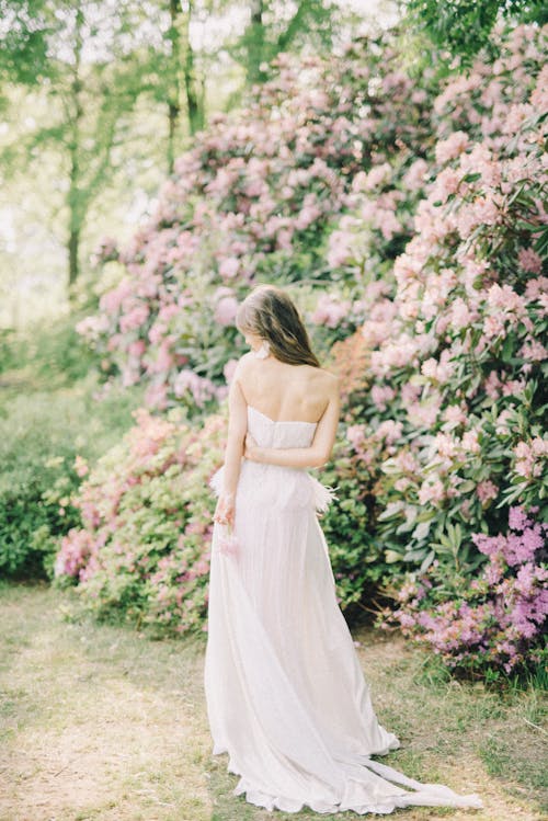 Back View of a Woman in a White Dress Posing in a Garden