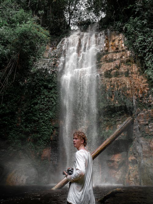 A Man in White Shirt Near the Waterfalls
