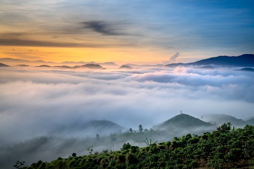 Green mountain range against cloudy sunset sky