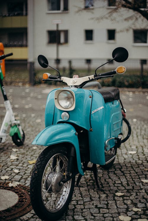 Blue and Black Motorcycle Parked on Sidewalk