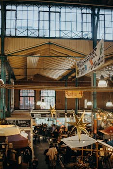 Warm and bustling indoor market scene with festive star decorations and food stalls.