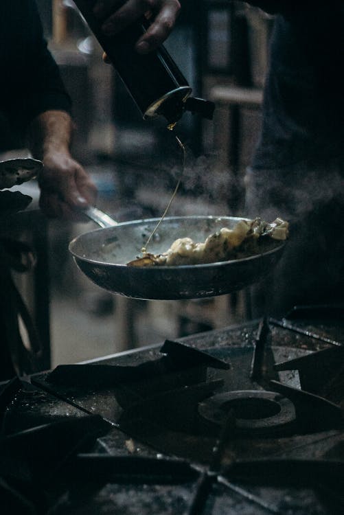 Person Cooking Food on Stainless Steel Bowl